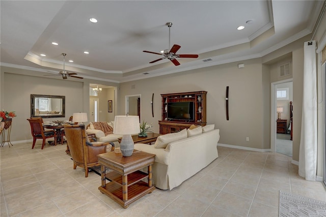 living area with a tray ceiling, crown molding, and a ceiling fan
