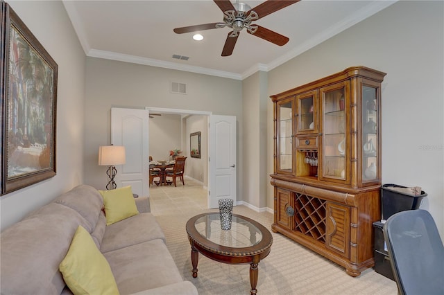 living area featuring visible vents, crown molding, and ceiling fan