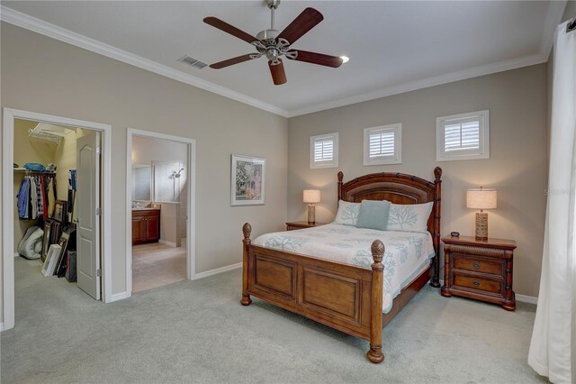 bedroom featuring a walk in closet, visible vents, light colored carpet, and crown molding