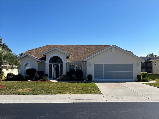 single story home with a garage and a front yard