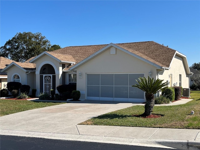 ranch-style home with a garage, central AC unit, and a front lawn