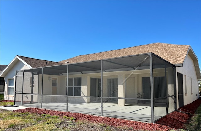 rear view of property with a patio area and glass enclosure