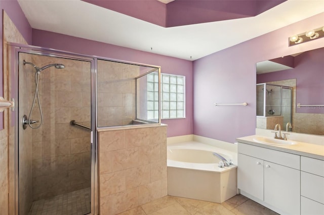 bathroom featuring a garden tub, a shower stall, tile patterned floors, and vanity