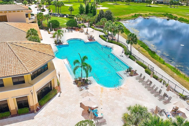 pool with a water view, a patio area, and fence