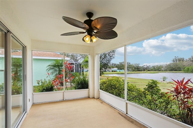 unfurnished sunroom with a water view, plenty of natural light, and a ceiling fan