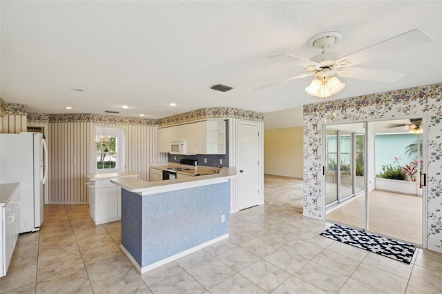 kitchen featuring ceiling fan, white appliances, a textured ceiling, and wallpapered walls