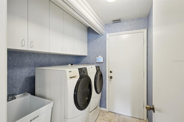 washroom with washing machine and dryer, a sink, and wallpapered walls