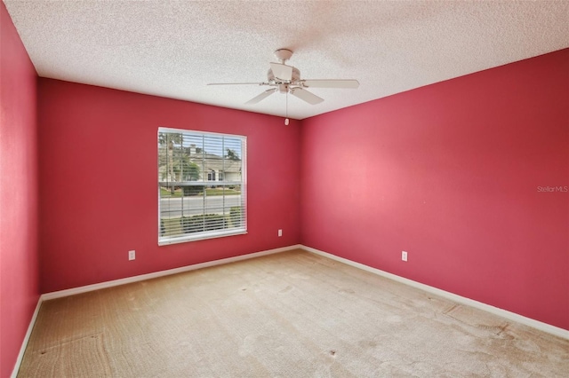 carpeted spare room with baseboards and a textured ceiling