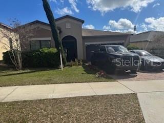 view of front of house featuring a garage and a front lawn