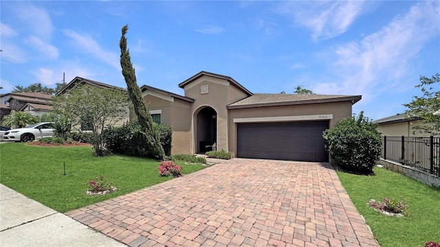 9362 Oglethorpe Dr, Groveland, FL 34736 - view of front of house featuring stucco siding, an attached garage, and decorative driveway