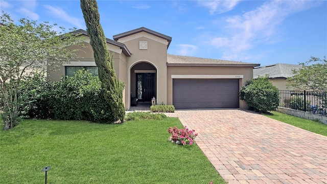 9362 Oglethorpe Dr, Groveland, FL 34736 - view of front of home featuring a garage, stucco siding, and decorative driveway