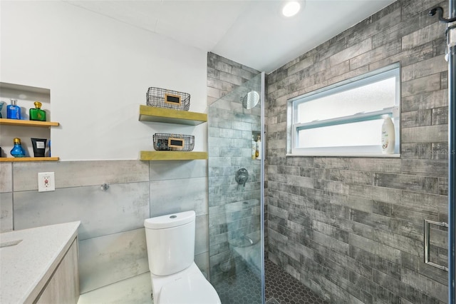 bathroom with vanity, an enclosed shower, tile walls, and toilet