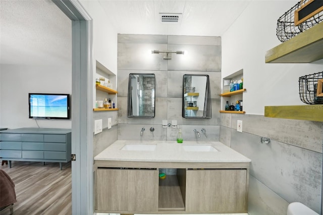 bathroom featuring hardwood / wood-style flooring, vanity, and backsplash