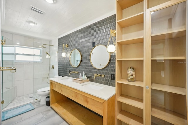 bathroom with tiled shower, vanity, toilet, and tile walls