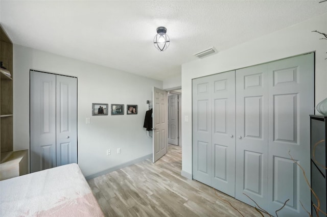 bedroom with a textured ceiling and light wood-type flooring