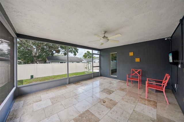 unfurnished sunroom with ceiling fan