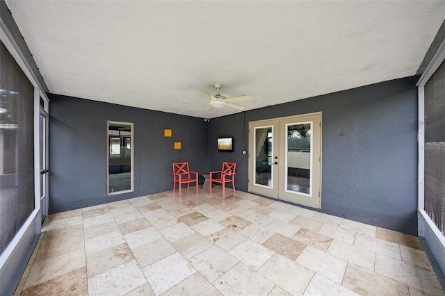 unfurnished sunroom featuring french doors and ceiling fan