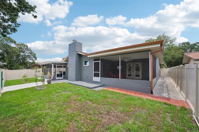 back of property featuring ceiling fan, a yard, a patio, and a sunroom