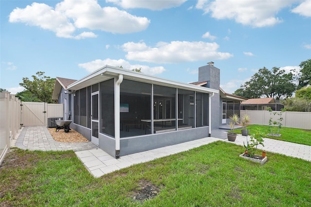 back of property featuring a yard, a sunroom, and central air condition unit