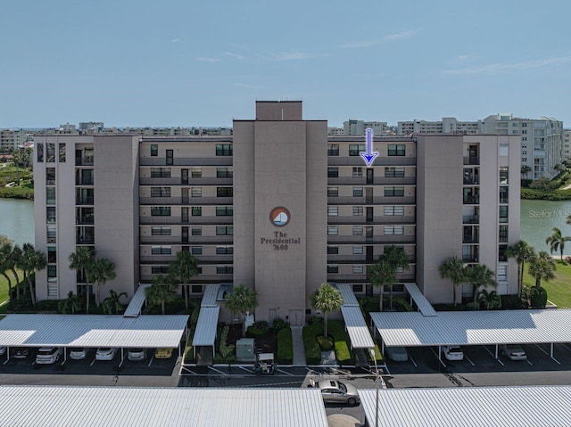 view of building exterior featuring a water view and uncovered parking