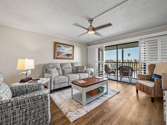 living room featuring wood finished floors, a ceiling fan, and ornamental molding