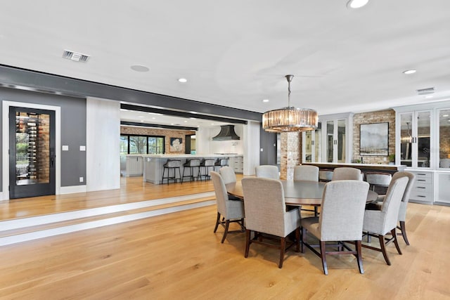 dining space with an inviting chandelier and light hardwood / wood-style floors