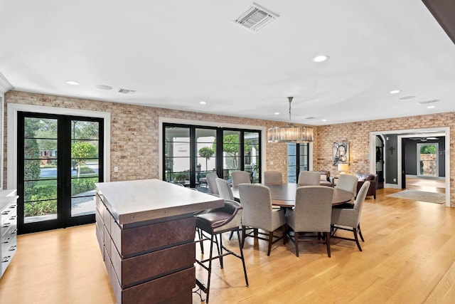 dining space featuring french doors, light wood-type flooring, and a wealth of natural light