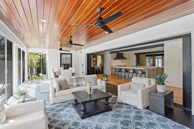 living room with wood ceiling and ceiling fan