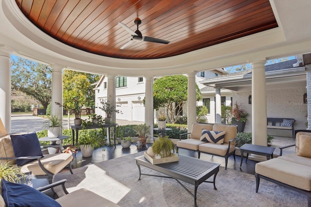 sunroom featuring ceiling fan, a raised ceiling, decorative columns, and wooden ceiling