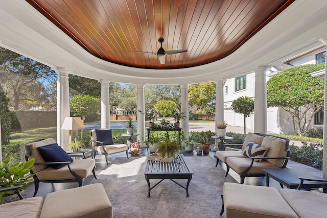 sunroom featuring a raised ceiling, a healthy amount of sunlight, and wooden ceiling