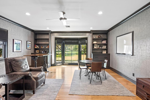 dining room with crown molding, light hardwood / wood-style floors, and ceiling fan