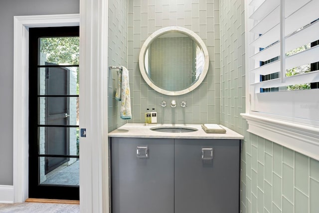 bathroom with vanity and tile walls