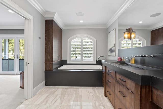 bathroom with crown molding, a wealth of natural light, and a tub