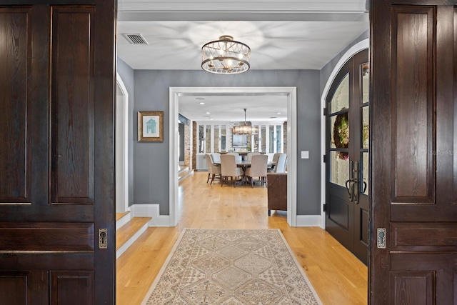 foyer featuring a chandelier and light wood-type flooring