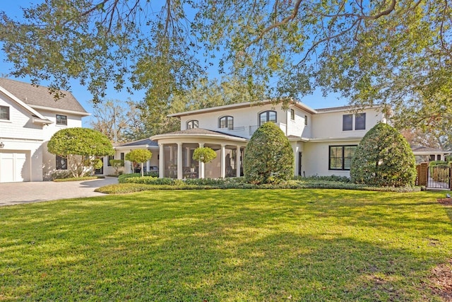 view of front of home featuring a sunroom and a front lawn