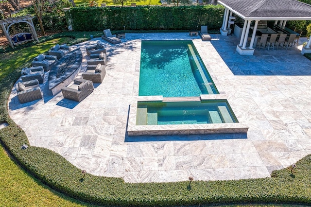 view of pool with a bar, a gazebo, a patio, and an in ground hot tub