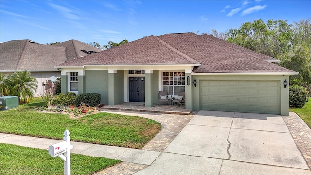 ranch-style home with an attached garage, a shingled roof, stucco siding, concrete driveway, and a front lawn