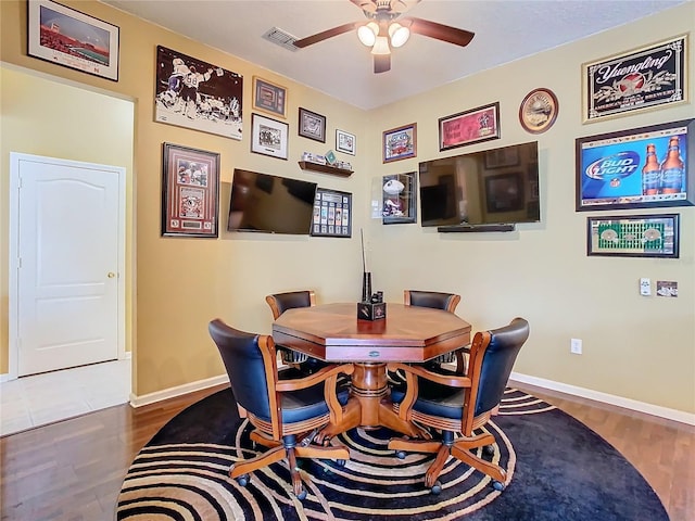 dining area featuring baseboards, wood finished floors, visible vents, and a ceiling fan