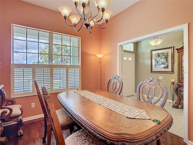 dining room featuring a notable chandelier, baseboards, and wood finished floors