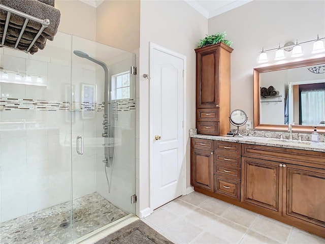 bathroom featuring a stall shower, tile patterned flooring, crown molding, and vanity