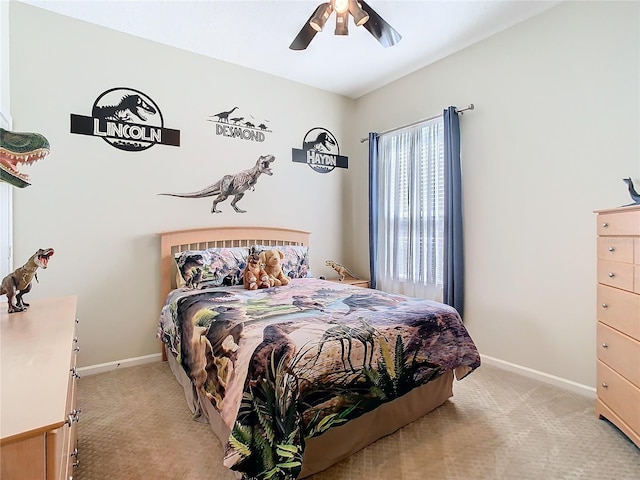 bedroom with a ceiling fan, light colored carpet, and baseboards