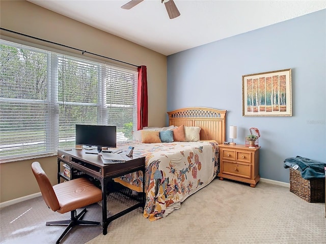 bedroom featuring a ceiling fan, light colored carpet, and baseboards