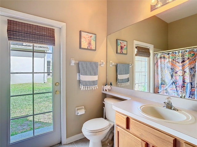 bathroom featuring curtained shower, tile patterned flooring, vanity, and toilet