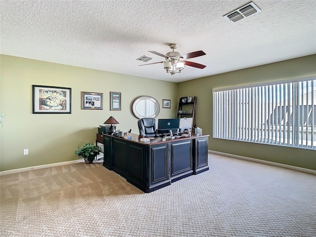 office area with a ceiling fan, light colored carpet, visible vents, and baseboards