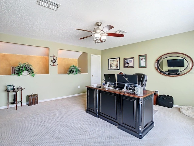 office featuring a textured ceiling, light carpet, and visible vents