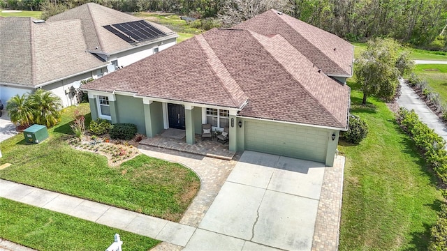 25950 Risen Star Dr, Wesley Chapel, FL 33544 - view of front of house with a front yard, a shingled roof, an attached garage, stucco siding, and driveway
