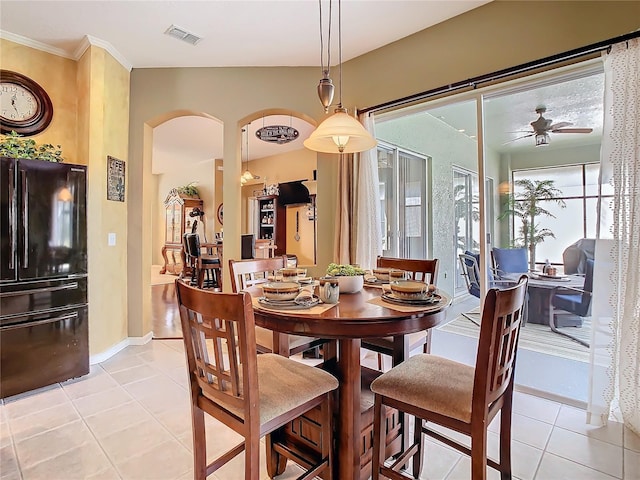 25950 Risen Star Dr, Wesley Chapel, FL 33544 - dining area featuring light tile patterned floors, ceiling fan, arched walkways, visible vents, and baseboards
