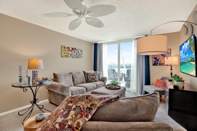 living room with ceiling fan, a textured ceiling, light tile patterned floors, and floor to ceiling windows