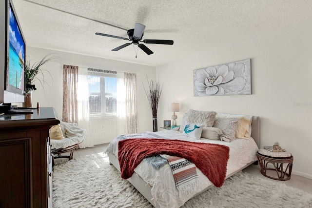 bedroom with ceiling fan and a textured ceiling