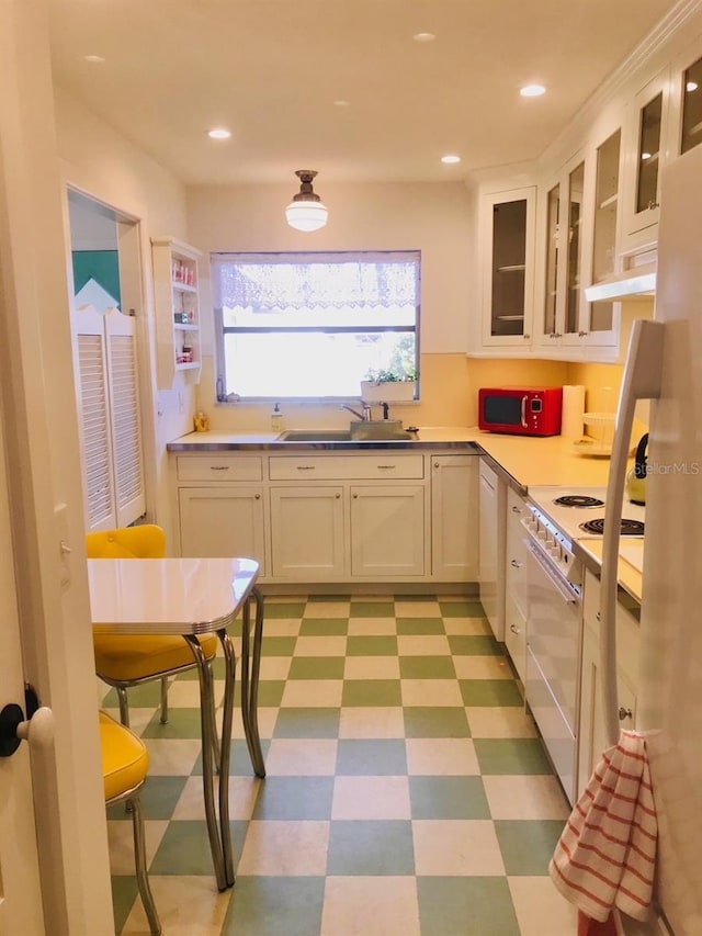 kitchen with sink, electric range, and white cabinets